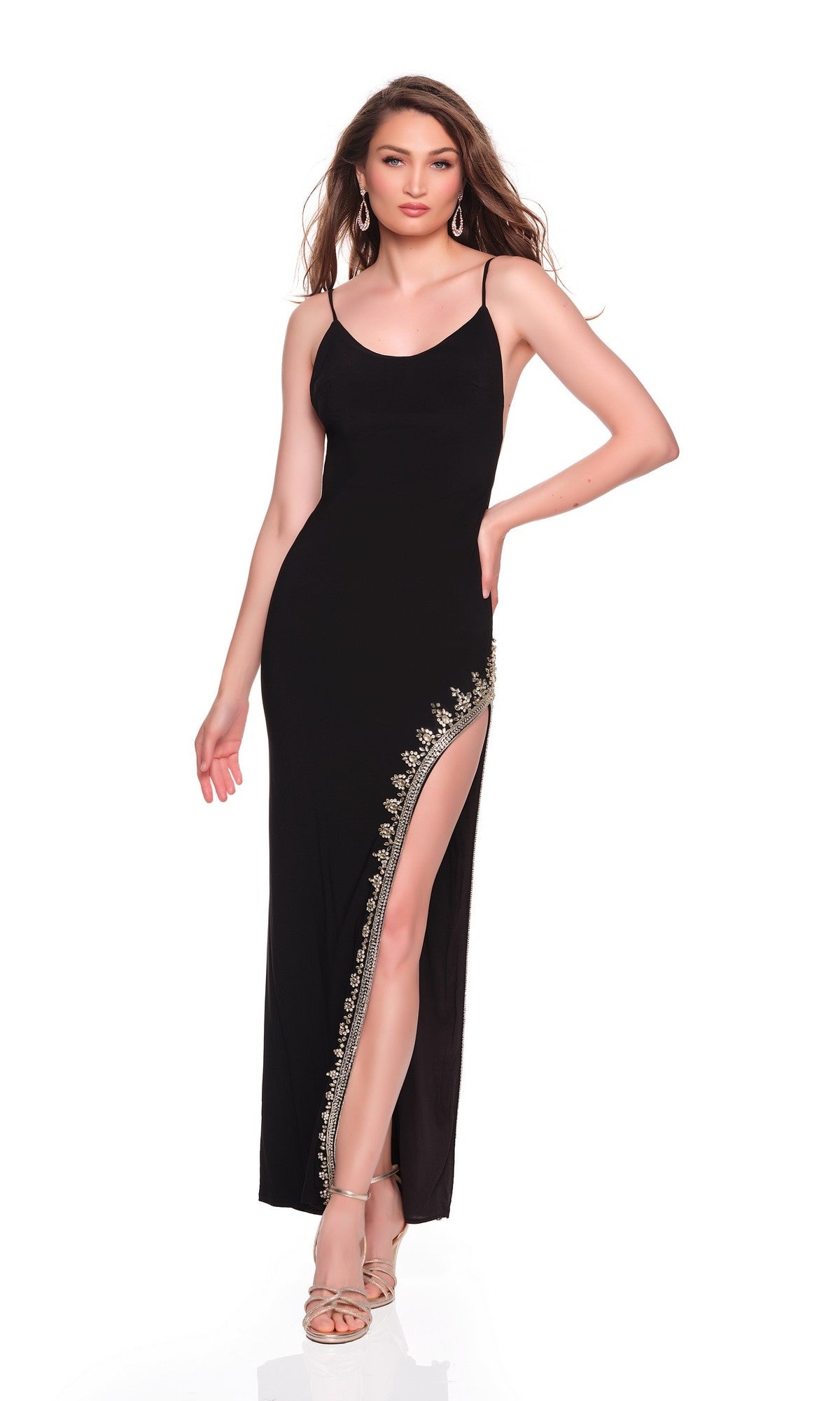 A woman models the Dave and Johnny 12819 long prom dress—a sleeveless black jersey gown with a high-leg slit and gold embroidery—posing against a plain white background.